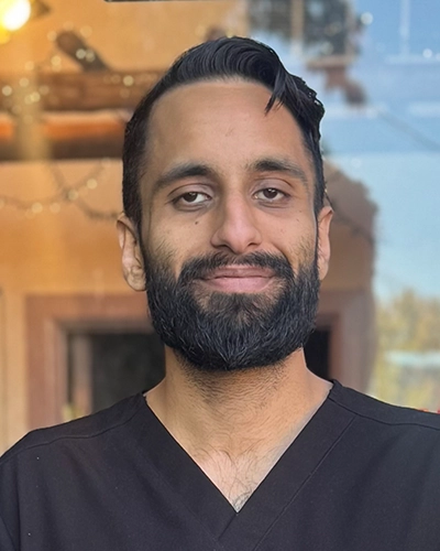Sukhmeet Mand smiling while wearing a black shirt.