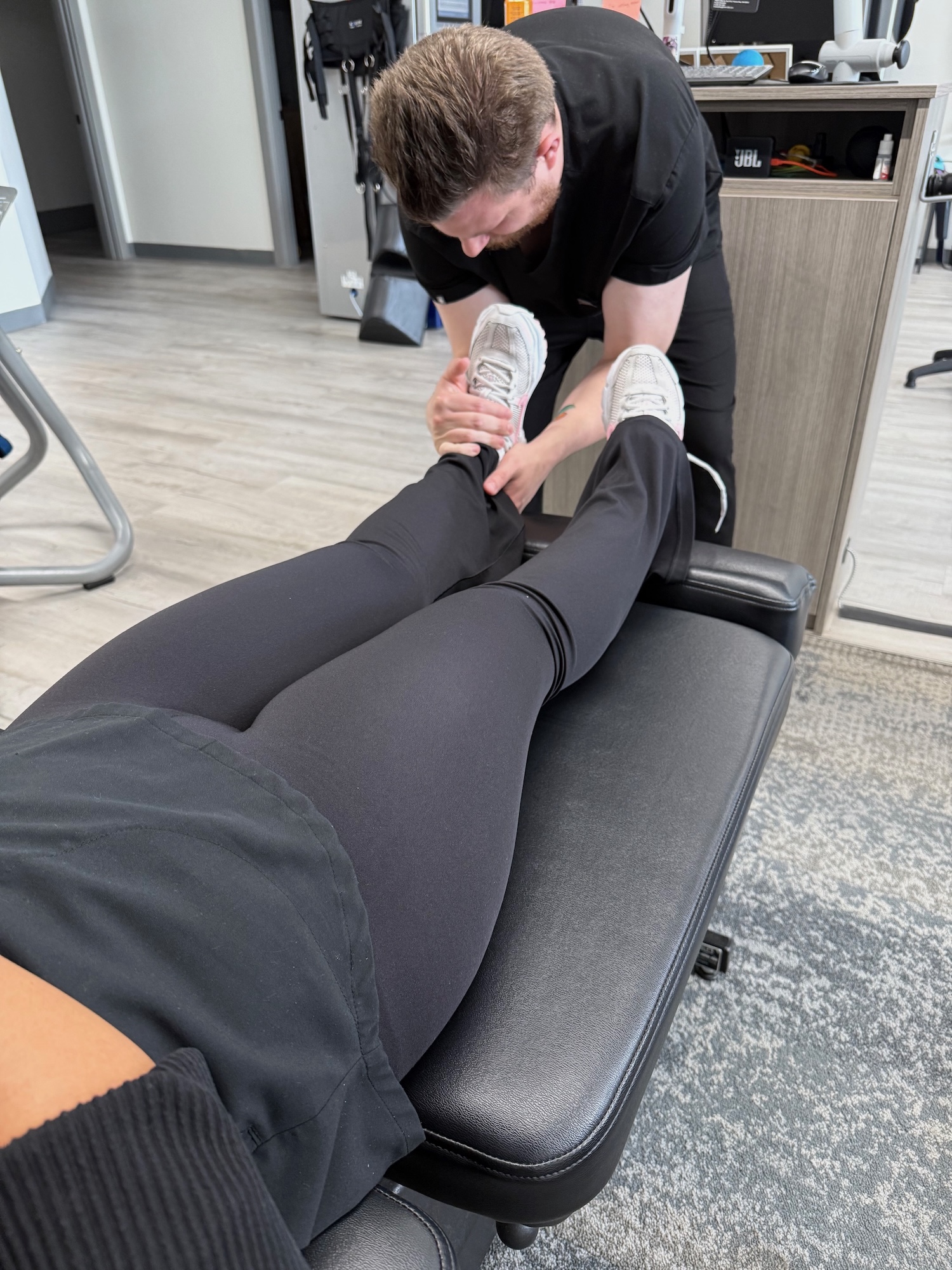 Chiropractor examining a neuropathy patient's legs at Chiro 1st