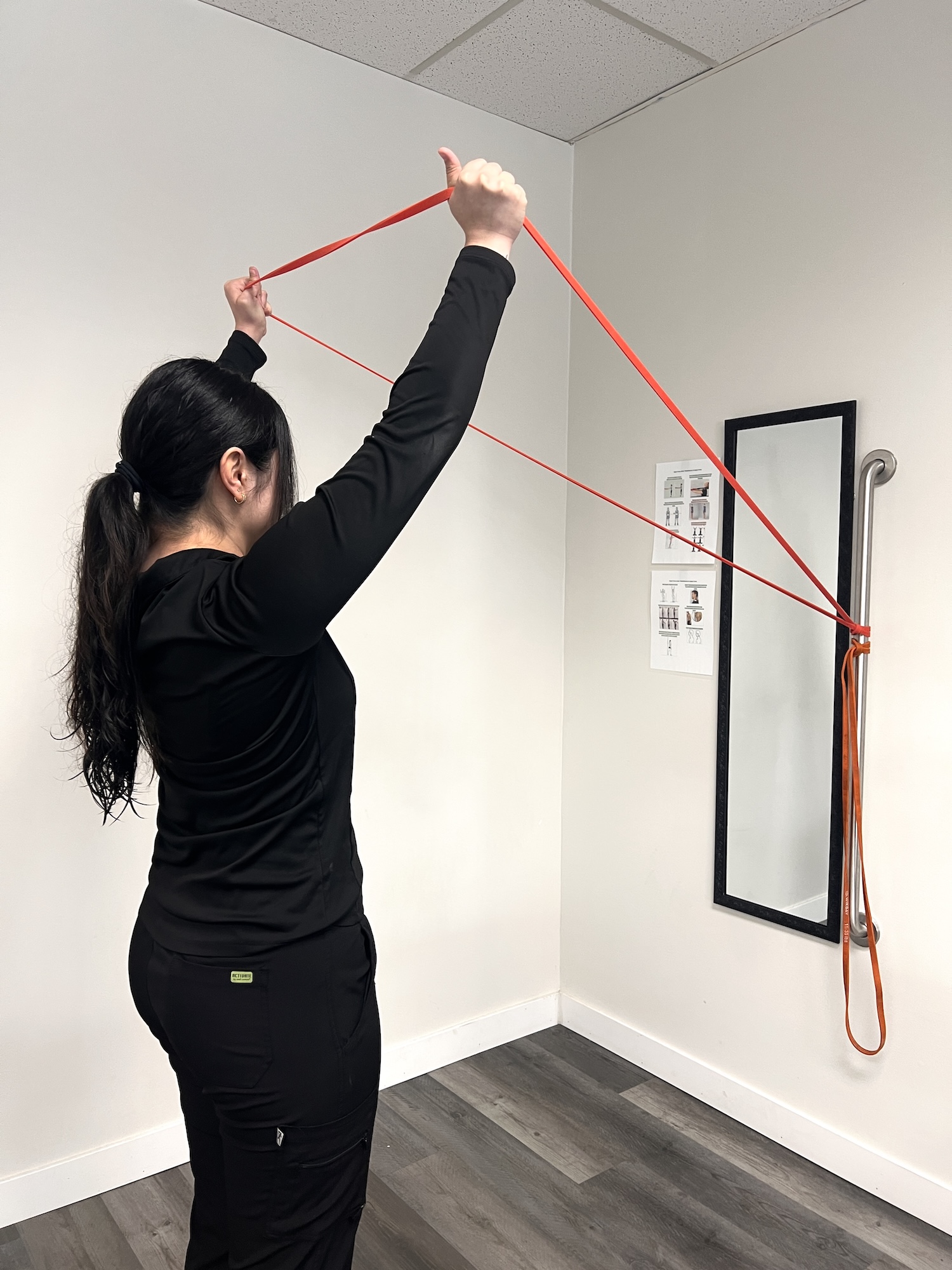 Patient doing a resistance band shoulder exercise at Chiro 1st