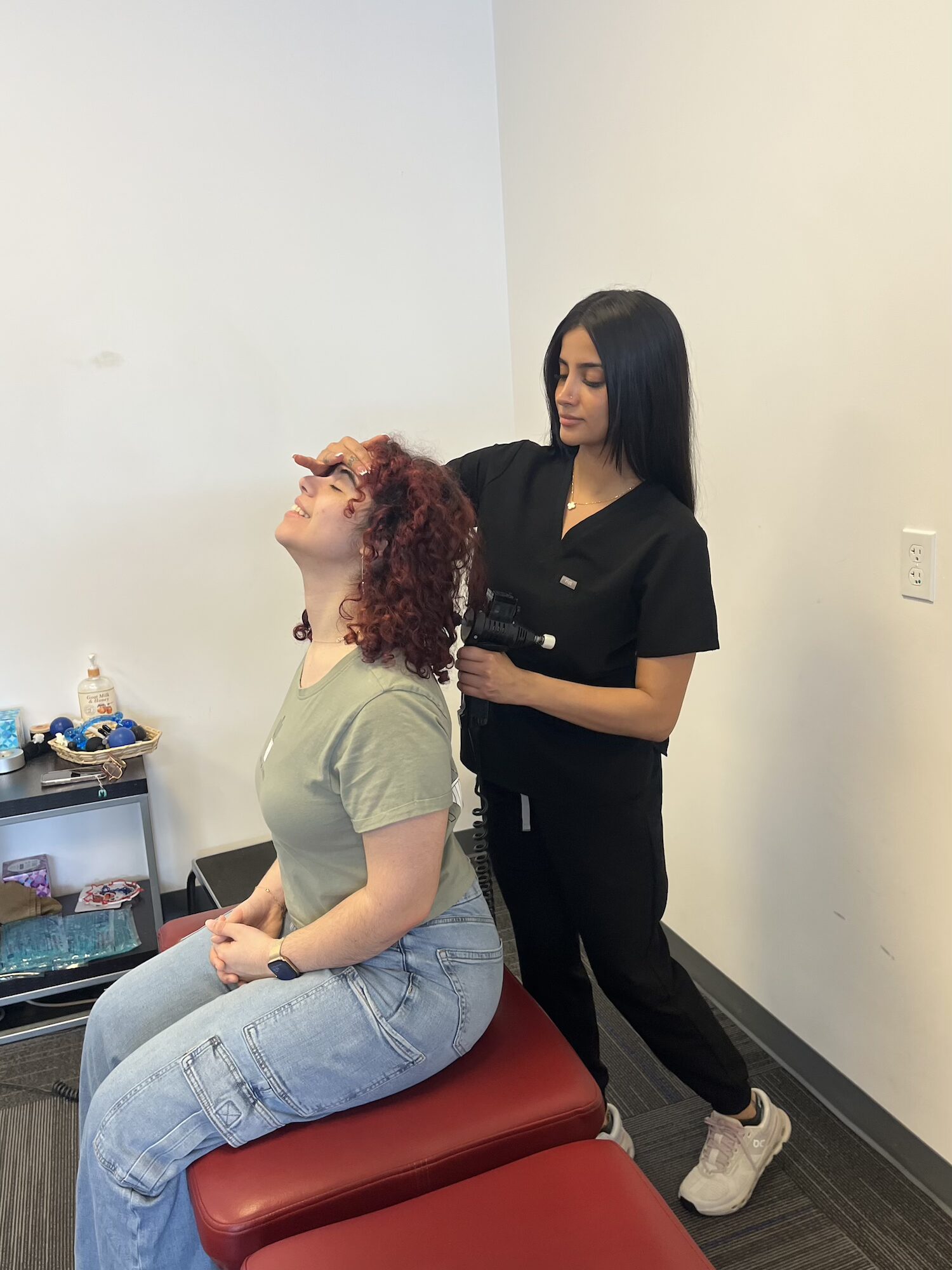 Chiropractor checking neck movement with a patient at Chiro 1st